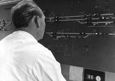 159791 Afbeelding van een treindienstleider bij CVL-bedieningstableau in het seinhuis (CVL-post) van de N.S. te Zutphen.