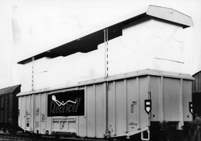 154135 Afbeelding van een beladen perswagen van de N.S. voor het vervoer van schuimrubber te Kesteren met geopend dak.