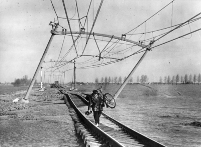 157030 Afbeelding van een eenzame fietser op de verzakte spoorlijn nabij Moerdijk na de watersnoodramp.
