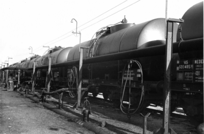 164322 Afbeelding van ketelwagens met ruwe aardolie bij het overlaadstation van een olieraffinaderij te Pernis.