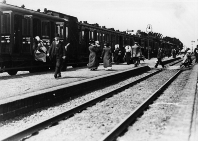 154616 Gezicht op het perron van het station Goes te Goes met reizigers en een trein bestaande uit houten rijtuigen.