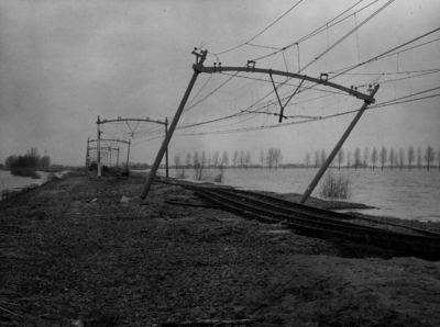157049 Afbeelding van de weggespoelde spoorlijn en een scheefgezakt bovenleidingsportaal, nabij Moerdijk, na de ...