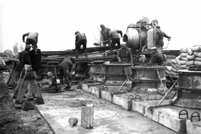 164313 Afbeelding van de fabricage van betonnen funderingsblokken voor bovenleidingsmasten op het emplacement van het ...