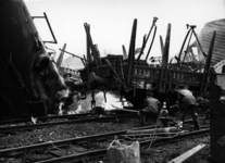 155737 Afbeelding van de ontspoorde goederentrein bij Barneveld met twee brandweerlieden die een in brand gevlogen ...