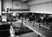 152603 Interieur van het N.S.-station Rotterdam C.S. te Rotterdam: de hal, met voorjaarsbloemen.