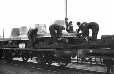164316 Afbeelding van het voor transport gereedmaken van betonnen funderingsblokken voor bovenleidingsmasten, ...