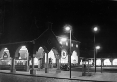 150418 Gezicht op een gedeelte van de zij- en voorgevel van het N.S.-station 's-Hertogenbosch te 's-Hertogenbosch bij avond.