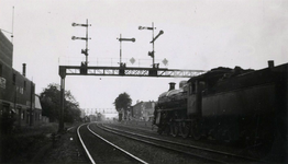 164693 Gezicht op de seinbrug met de inrijseinen van het N.S.-station Tilburg te Tilburg (westzijde), met trein 216 ...