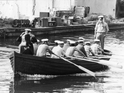102774 Afbeelding van de docentenploeg tijdens de roeiwedstrijd tussen leerlingen en docenten van de Gemeentelijke ...