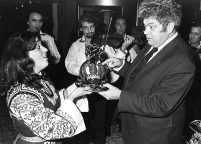 102713 Afbeelding van burgemeester H.J.L. Vonhoff die van een in klederdracht getooide Bulgaarse een geschenk ...