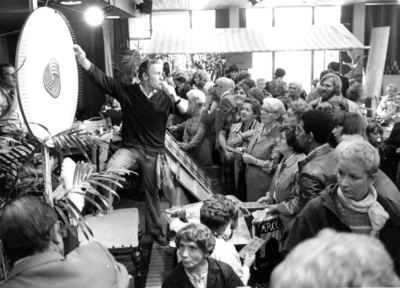 103054 Afbeelding van de belangstellenden rond het rad van avontuur in de recreatiezaal van het Woon- en Zorgcentrum De ...