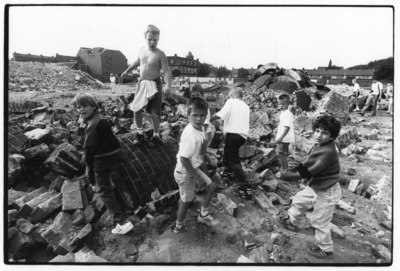 103519 Afbeelding van enkele kinderen op de restanten van de opgeblazen schoorsteen van het voormalige Openbaar ...