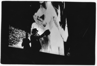 103724 Afbeelding van een explicateur tijdens een vertoning van de eerste films van Louis en Auguste Lumière uit 1895 ...