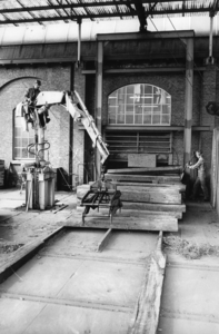 167699 Afbeelding van de afvoer van oude dwarsliggers op de stapelplaats van de N.S. te Crailoo.