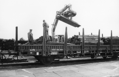 167700 Afbeelding van de afvoer van oude dwarsliggers op de stapelplaats van de N.S. te Crailoo.