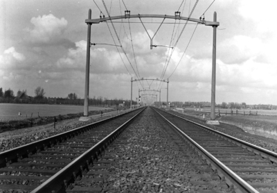 165741 Gezicht op de spoorlijn tussen Lage Zwaluwe en Dordrecht, met de betonnen bovenleidingsportalen.