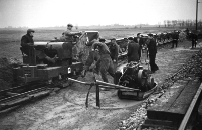 165751 Afbeelding van het storten van beton langs de spoorlijn bij Duivendrecht ten behoeve van de baanverzwaring ...
