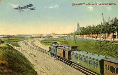 170047 Gezicht op het emplacement van het H.S.M.-station IJmuiden te IJmuiden, met een binnenkomende trein en ...