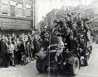 350119 Afbeelding van een truck beladen met uitbundige mensen, in de Potterstraat te Utrecht, tijdens de intocht van de ...