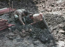 827219 Afbeelding van twee archeologen aan het werk in de bouwput voor het nieuwe warenhuis van V&D aan Achter ...