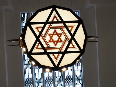 827854 Afbeelding van de onderzijde van de art-deco kroonluchter met 106 gloeilampen en davidsterren in het gebouw van ...